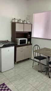 a small kitchen with a table and a microwave at Flat Viçosa in Viçosa do Ceará