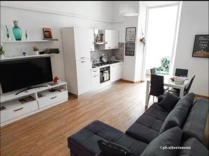 a living room with a couch and a kitchen at Al mare da Alfred and Cate - Ampio appartamento a due passi dal Centro Storico e dalla Stazione con AC in Piombino