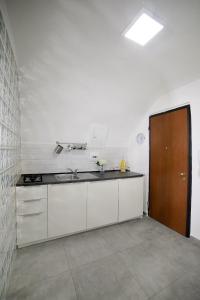 a kitchen with white cabinets and a brown door at Casa Sant Anna in Naples
