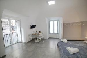 a white bedroom with a bed and a table at Casa Sant Anna in Naples