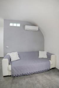 a bed in a room with a white wall at Casa Sant Anna in Naples