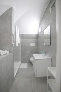 a white bathroom with a sink and a toilet at Casa Sant Anna in Naples +21 photos