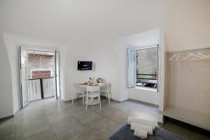 a white room with a table and two windows at Casa Sant Anna in Naples