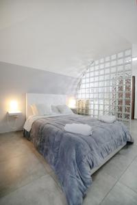 a white bedroom with a large bed with a large window at Casa Sant Anna in Naples