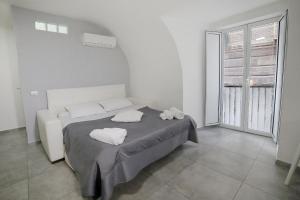 a bedroom with a bed with two towels on it at Casa Sant Anna in Naples