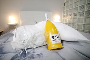 a bottle of champagne and glasses on a bed at Casa Sant Anna in Naples