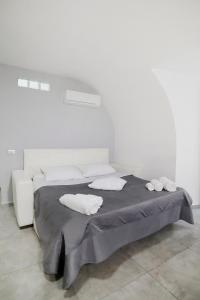 a white bedroom with a bed with two white pillows at Casa Sant Anna in Naples
