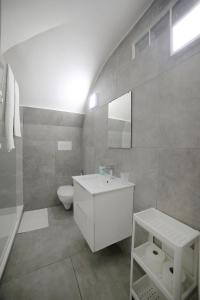 a white bathroom with a sink and a toilet at Casa Sant Anna in Naples
