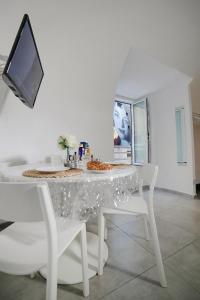 a white dining room with a white table and chairs at Casa Sant Anna in Naples