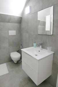 a bathroom with a white sink and a toilet at Casa Sant Anna in Naples