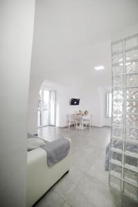 a white living room with a white couch and a table at Casa Sant Anna in Naples
