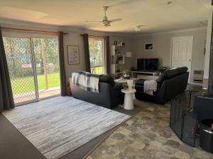 a living room with two couches and a table at South Bruny Island Retreat in Lunawanna