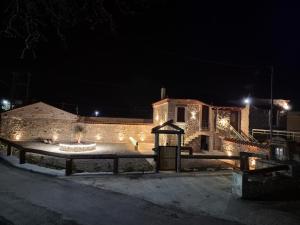 a building with lights on it at night at Olive Stone House in Alíartos +10 photos