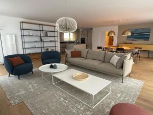a living room with a couch and a table at Côté Mer - Vue exceptionnelle - Rooftop - SPA in Roscoff