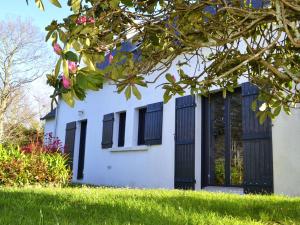 a white house with black windows and green grass at Maison lumineuse avec jardin entre plages de Cap-Coz et Beg-Meil, proche activités nautiques - FR-1-481-173 in Fouesnant