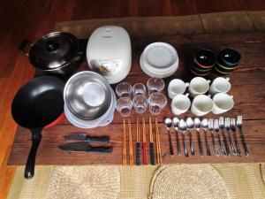 a table with a bunch of utensils and wine glasses at Tokashiki Guest House in Tokashiki