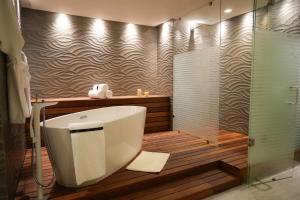 a bathroom with a large tub and a shower at Metria Hotel in León