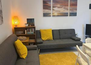 キドリントンにある4 Bedroom House, Oxfordのリビングルーム(ソファ2台、黄色い枕付)