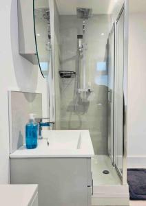 キドリントンにある4 Bedroom House, Oxfordの洗面台とシャワー付きの白いバスルーム