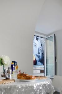 two pizzas on a table with a picture of a man at Casa Sant Anna in Naples