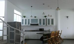 une cuisine avec des armoires blanches et une table et des chaises dans l'établissement ESCAPA DE LA RUTINA Y DISFRUTA Asia - Chocaya, à Asia