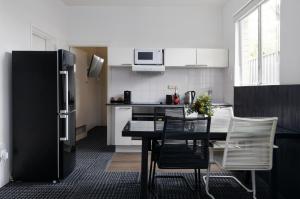 a kitchen with a table and chairs and a refrigerator at Siesta Central Apartments in Sale