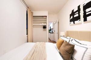 a bedroom with a large white bed and a closet at 1288-3RN New Renovated 1 Bedroom in UES in New York