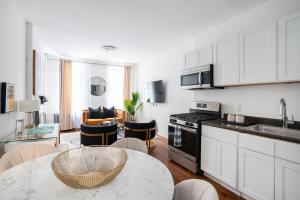 a kitchen with white cabinets and a table with a bowl at 1288-3RN New Renovated 1 Bedroom in UES in New York +12 photos