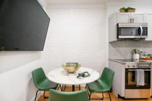 eine kleine Küche mit einem Tisch und grünen Stühlen in der Unterkunft 1288-3RS New Renovated 2 Bedrooms in UES in New York