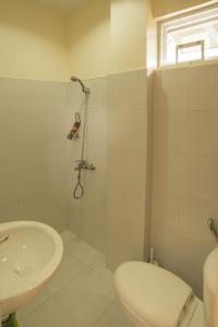 a white bathroom with a sink and a toilet at Oasi Fiore Bed & Breakfast in Panglao Island
