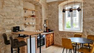 eine Küche mit Tisch und Stühlen und einem Fenster in der Unterkunft Calico Apartment's in Jelsa