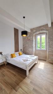 ein Schlafzimmer mit einem großen Bett und einer Backsteinwand in der Unterkunft Calico Apartment's in Jelsa