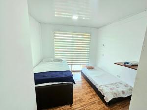 a small bedroom with two beds and a window at CASA QUINTA EL PARAiSo EN MESITAS DEL COLEGIO in El Colegio +14 photos