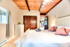 a bedroom with a large white bed with pink pillows at Chalet Ruby Rouge in Chertsey