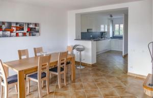 エーグ・モルトにあるBeautiful Home In Aigues-Mortesの木製のテーブルと椅子のあるキッチンとダイニングルーム