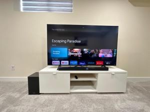 ein weißes Entertainment-Center mit einem Flachbildfernseher in der Unterkunft Private Cozy Spacious 1 bedroom basement suite in Winnipeg