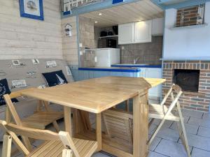 a wooden table and chairs in a kitchen at Maison rénovée proche mer avec piscine chauffée, tennis, WiFi, parking privé - Bretignolles-sur-Mer - FR-1-224A-72 in Brétignolles-sur-Mer