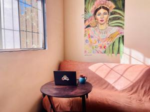 a table with a laptop on it next to a couch at Trotamundo Oaxaca Hostel in Oaxaca City