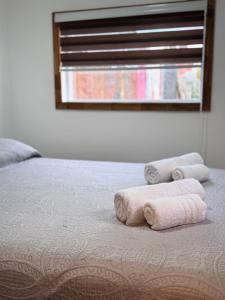 a bedroom with two rolled towels on a bed at Bosque Patagonia Lodge in Puerto Natales