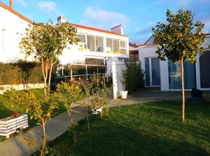 una casa blanca con árboles en el patio en Casas turísticas Lar Jardín - Parking privado, en Santiago de Compostela