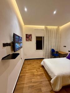 Una televisión o centro de entretenimiento en Chambre privée vue sur jardin