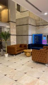 ein Wohnzimmer mit Sofas und einer Palme in der Unterkunft ATYAF ALKHIR HOTEl in Mekka