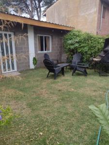 two chairs and a table in a yard at Amistad in Villa Gesell