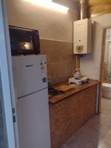 een keuken met een witte koelkast en een magnetron bij Amistad in Villa Gesell