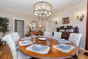 une salle à manger avec une table en bois et des chaises blanches dans l'établissement City Park Charm - Vintage Home with Modern Comforts, à Fort Collins