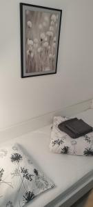 a bed with two pillows and a picture on the wall at Lamia in Osijek +18 photos