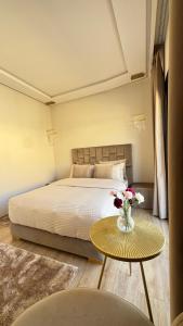 a bedroom with a bed and a table with flowers on it at Cozy Studio in Rabat City Center in Rabat