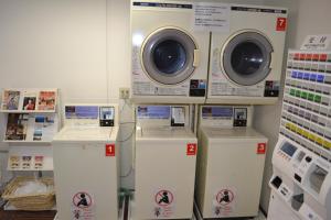 a laundry room with washers and dryers in a store at 1 Night 1980 Hostel Tokyo Asakusa Simple Stay in Tokyo