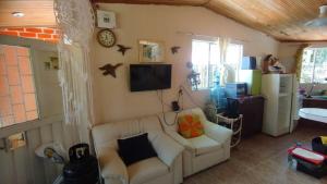 a living room with a white couch and a tv at country estate in Pasto