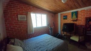 a bedroom with a bed and a brick wall at country estate in Pasto +7 photos